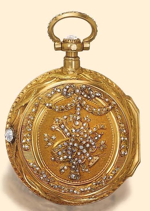The back of the 20K varicolored gold watch showing the applied diamond-set musical instruments and floral decoration, with the diamond-set bezel and thumb piece.