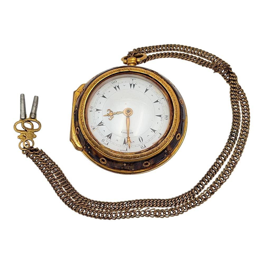 Front view of the Daniel de St Leu Ottoman-market pair-cased pocket watch within its tortoiseshell outer case, showing the dial and attached chain with keys