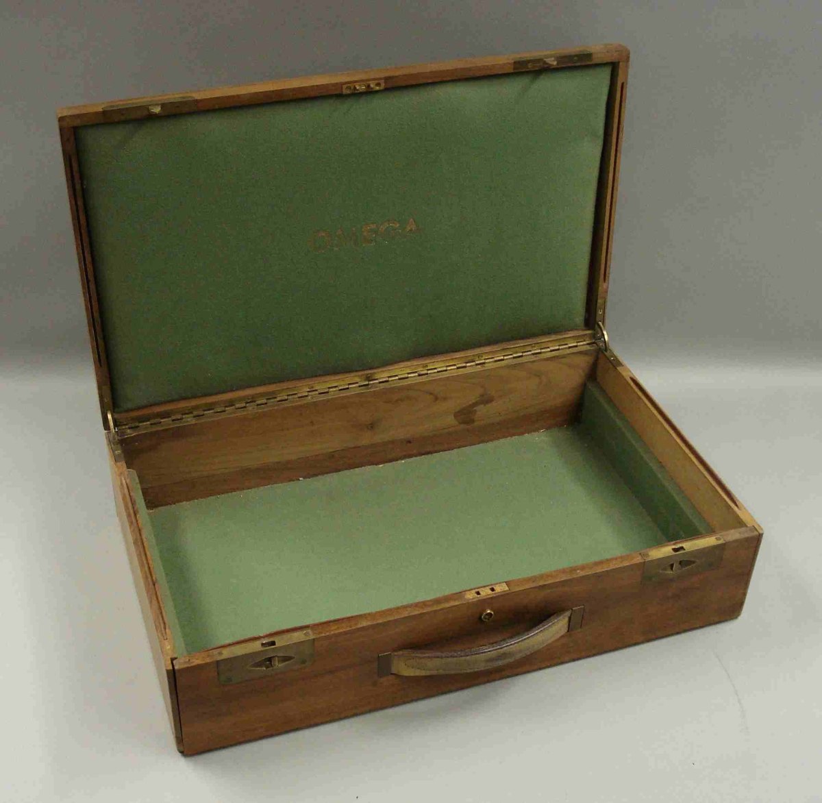 Open view of the Omega Watches salesman's wooden case showing interior lining and branding