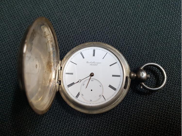 Front view of open pocket watch showing white dial, hands, subsidiary seconds subdial, and hinged front lid