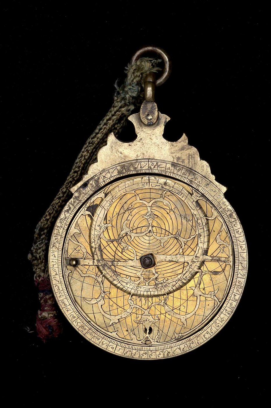 The obverse of the brass astrolabe, showing the intricate rete, degree-scaled limb, and the central nut-and-bolt assembly.