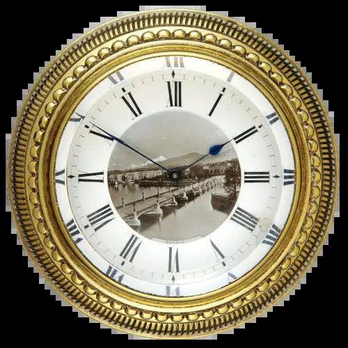 Dial view of the circular brass desk clock showing Roman numerals and a central scene of Geneva