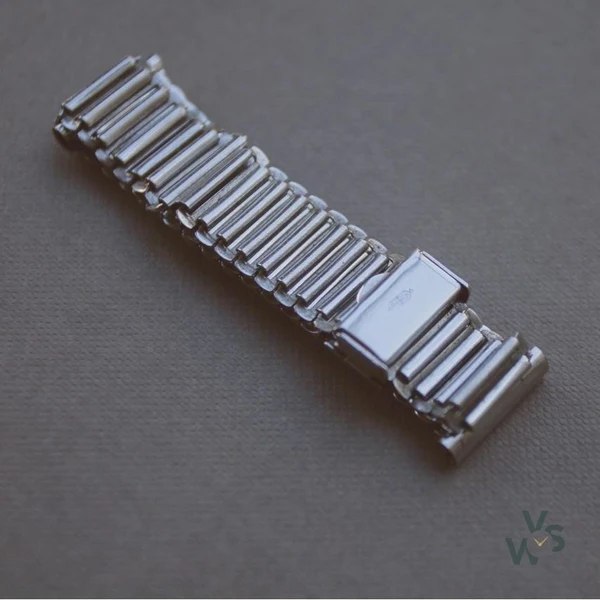 Angled view of the A. D. stainless steel watch bracelet showing folded rungs and clasp