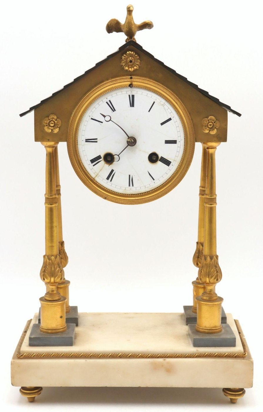 Full view of the 19th-century French Empire portico clock featuring the architectural temple design and bird finial.