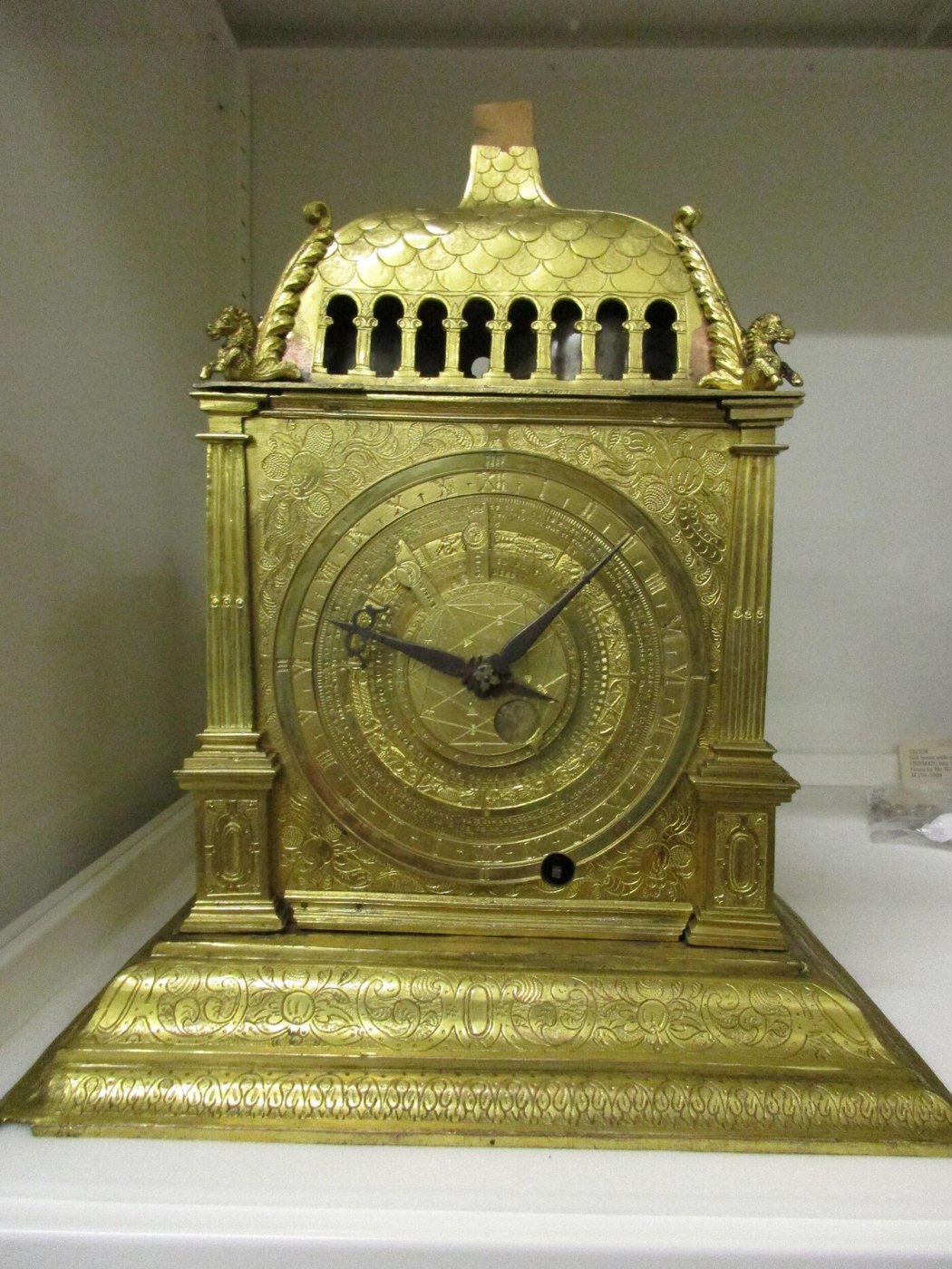 Front view of the astronomical table clock showing the main dial and the engraved gilt-bronze case.