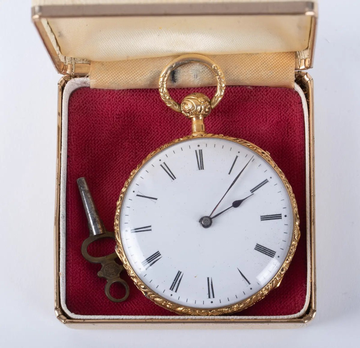Dial and case front of the open-face pocket watch with key in display box