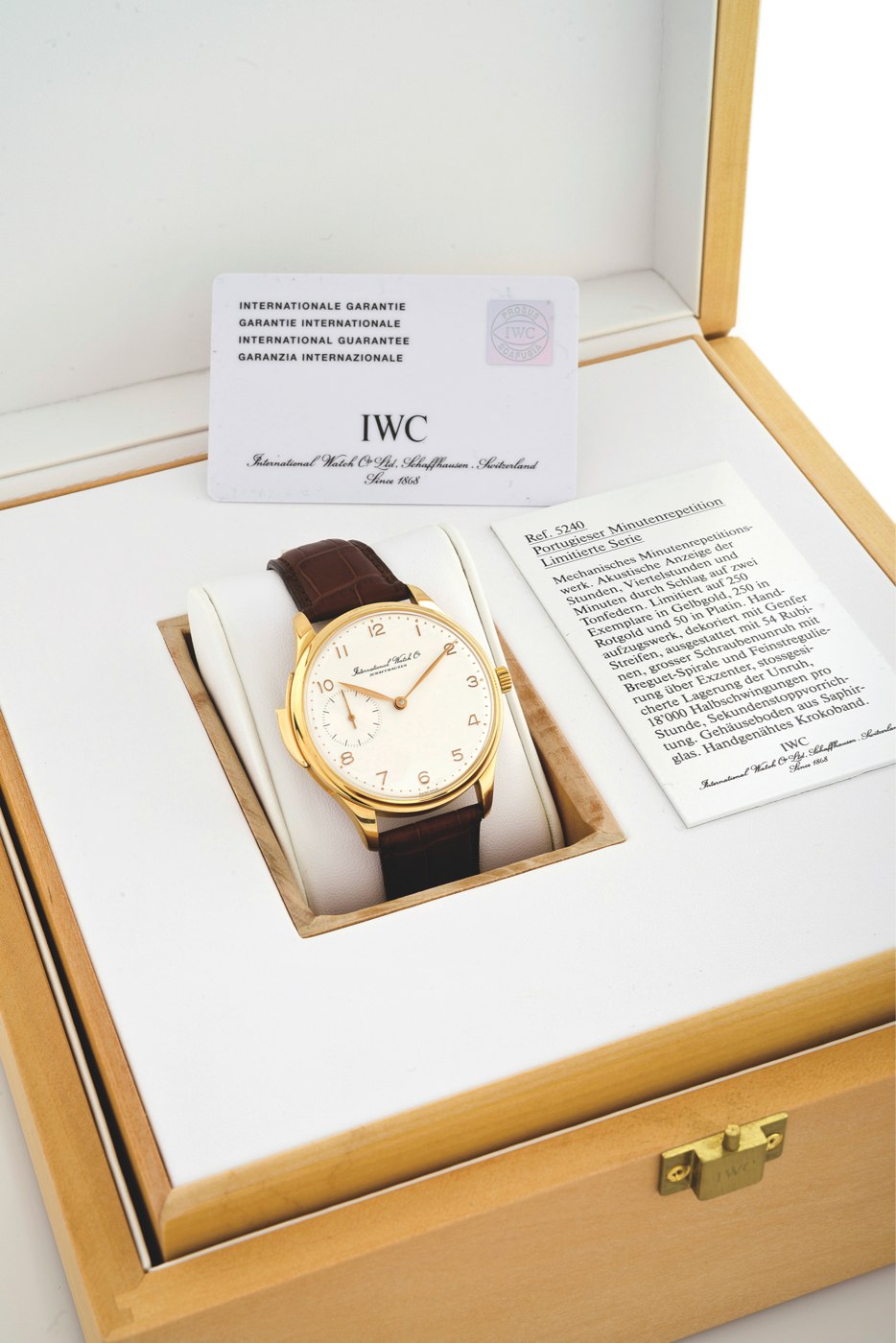 The IWC Portuguese Répétition Minutes Ref. 5240 inside its fitted wooden box, alongside accompanying documentation.