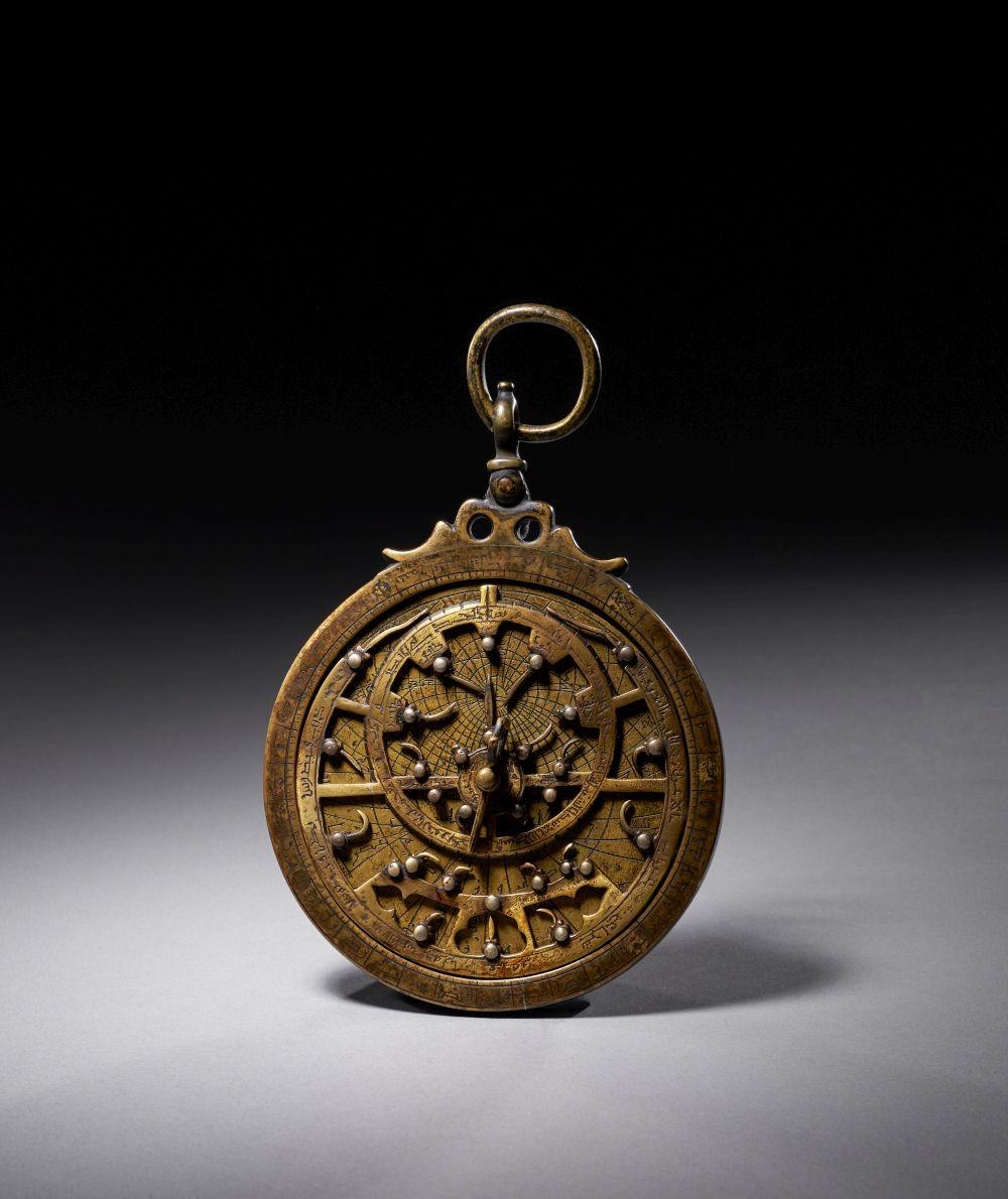 Full view of the brass astrolabe, showing the rete, throne, and suspension ring.