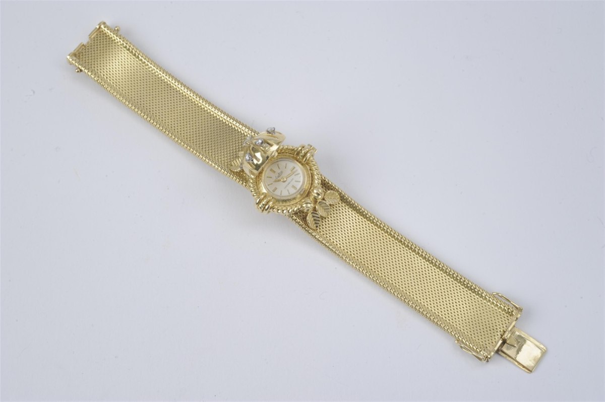 Full view of the open cocktail watch showing the small dial, hinged cover, and woven gold bracelet