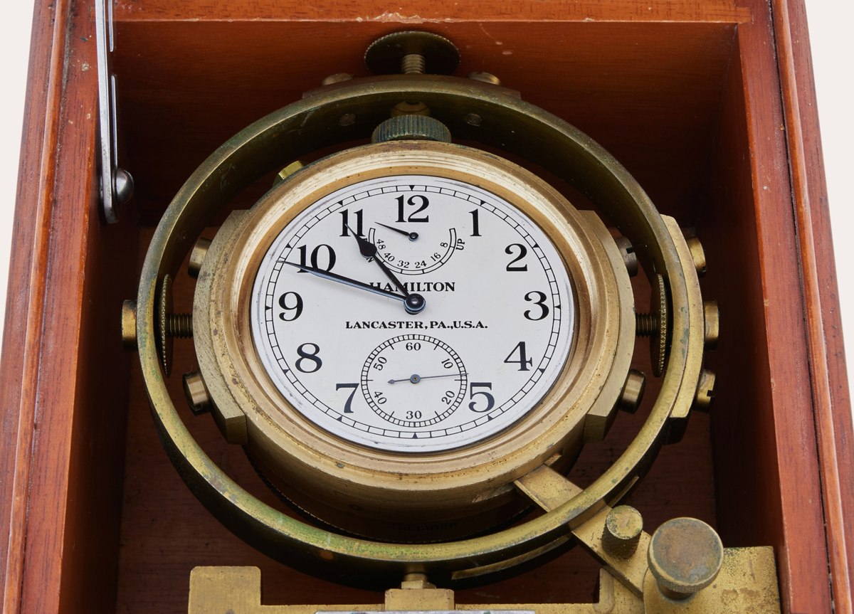 Top view of the silvered dial, brass gimbal mounting, and walnut housing of the Hamilton Model 22-21 marine deck watch
