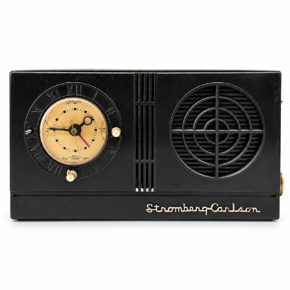 Front view of the Stromberg-Carlson clock radio showing the black cabinet, Sessions clock dial, and circular speaker grille.