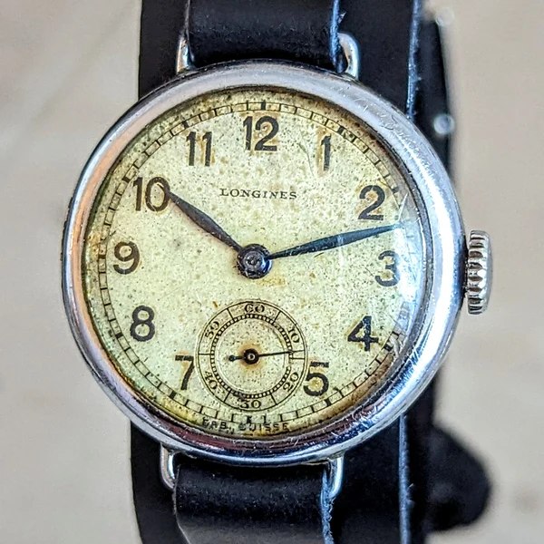 Front view of Longines wire lug wristwatch with patinated Arabic numeral dial