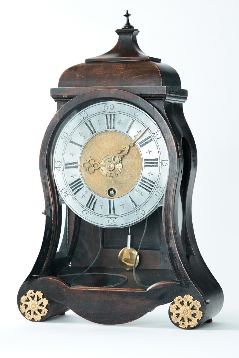 The curved blackened wood case has two round feet with applique rosettes decorated with flowers and leaves (MIH IV-15)