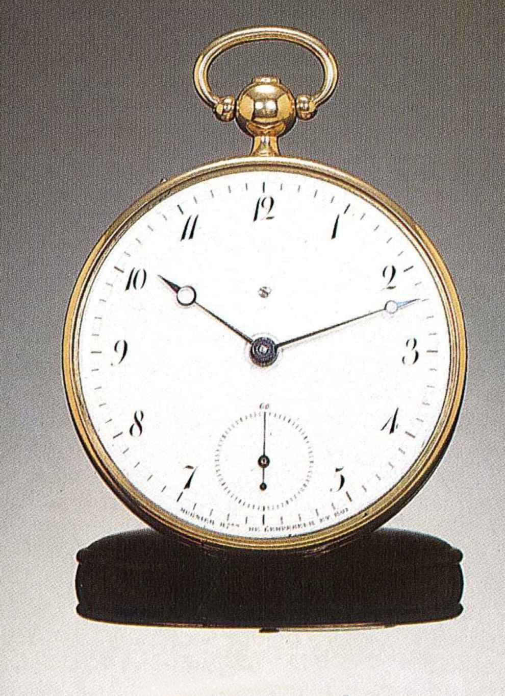 Front view of the 18k gold Mugnier clock-watch showing the white enamel dial and Breguet hands.