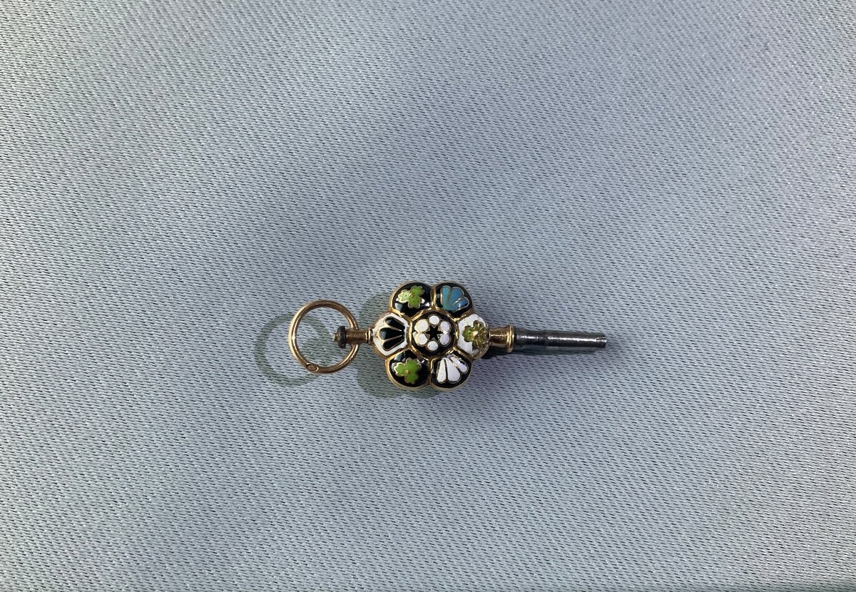 Full view of the gold and polychrome enameled pocket watch key showing suspension bail and winding shaft