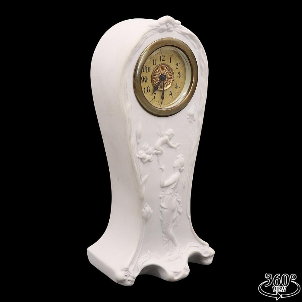Full view of the Rudolf Kämmer biscuit porcelain desk clock showing the figural porcelain relief and the integrated clock dial.