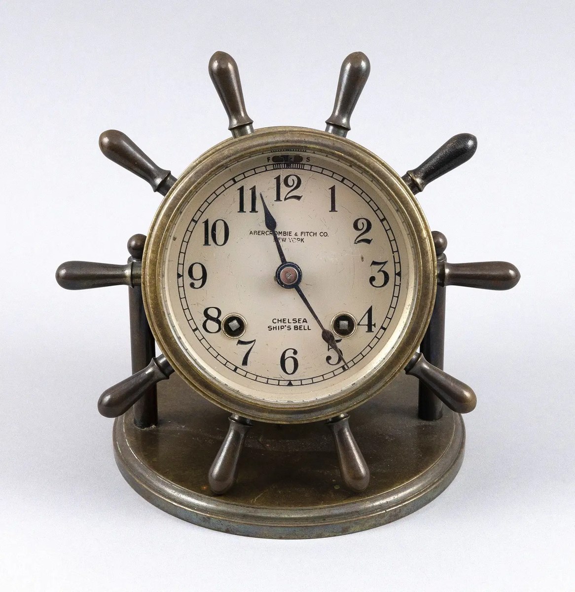 Front view of Chelsea brass ship's wheel desk clock on circular base