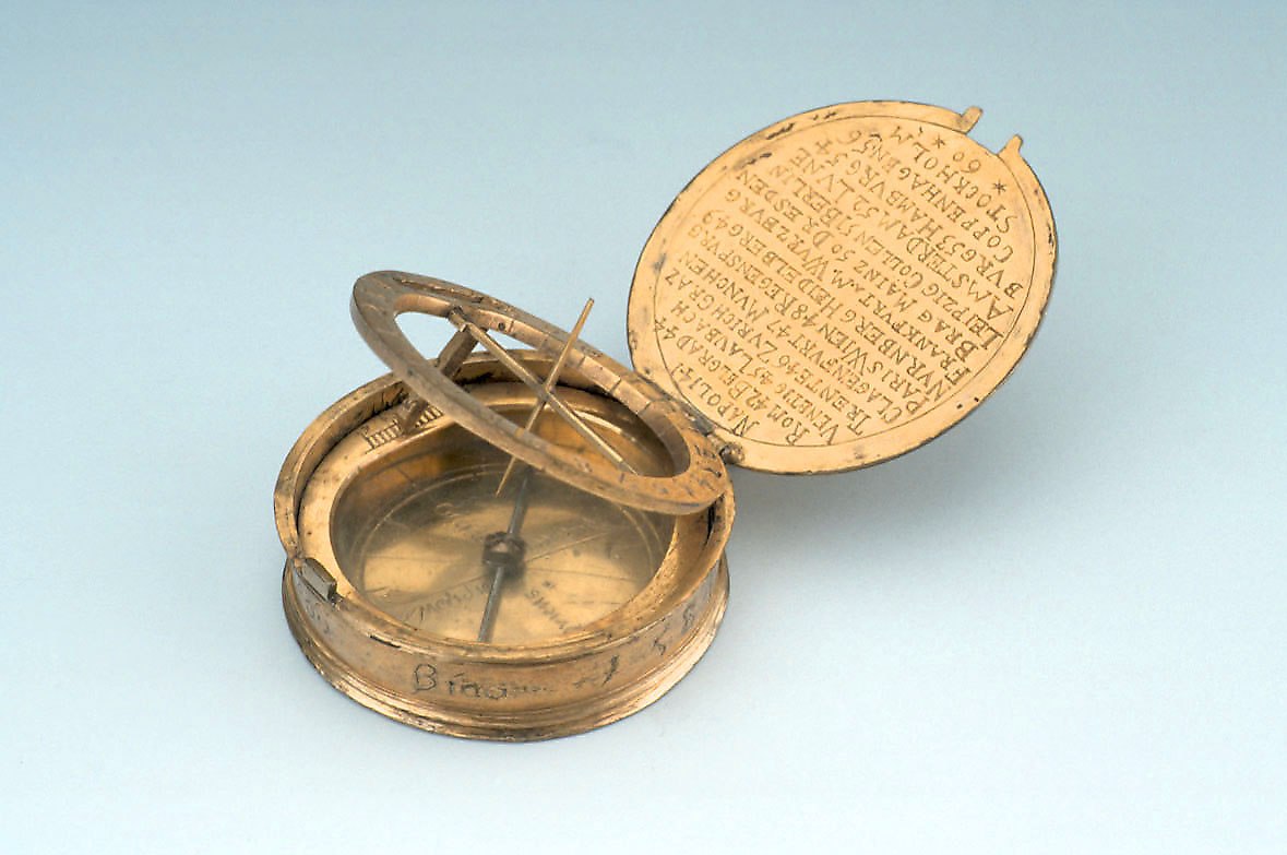 Equinoctial dial in gilt brass, dated 1584, showing the open lid with latitude table, the hour ring, and the compass.