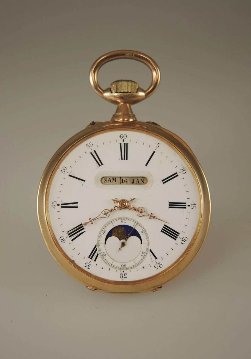 Front view of the 18K gold pocket watch showing the enamel dial, calendar apertures, and moon-phase indicator