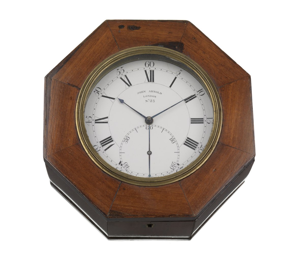 Top-down view of the marine chronometer dial through the glazed aperture of the octagonal mahogany case