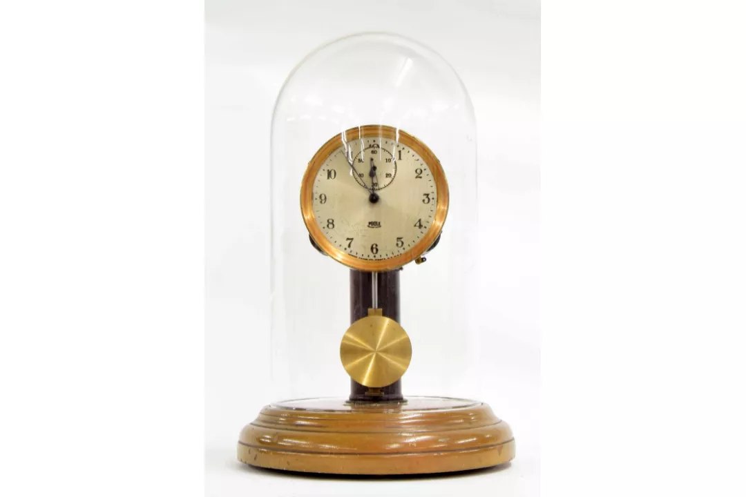 Poole electric mantel clock under glass dome on circular stepped base