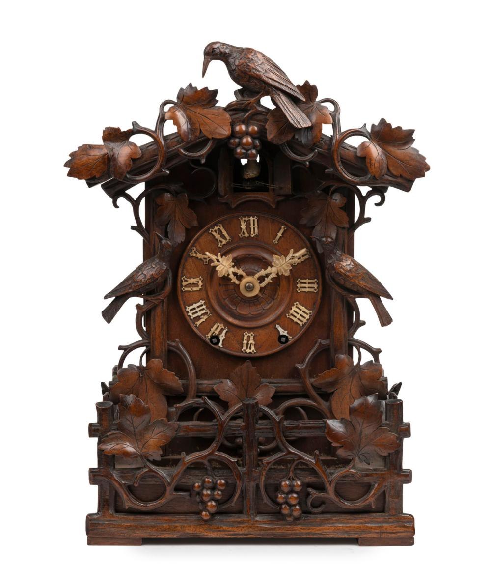 Front view of the chalet-style carved walnut cuckoo table clock