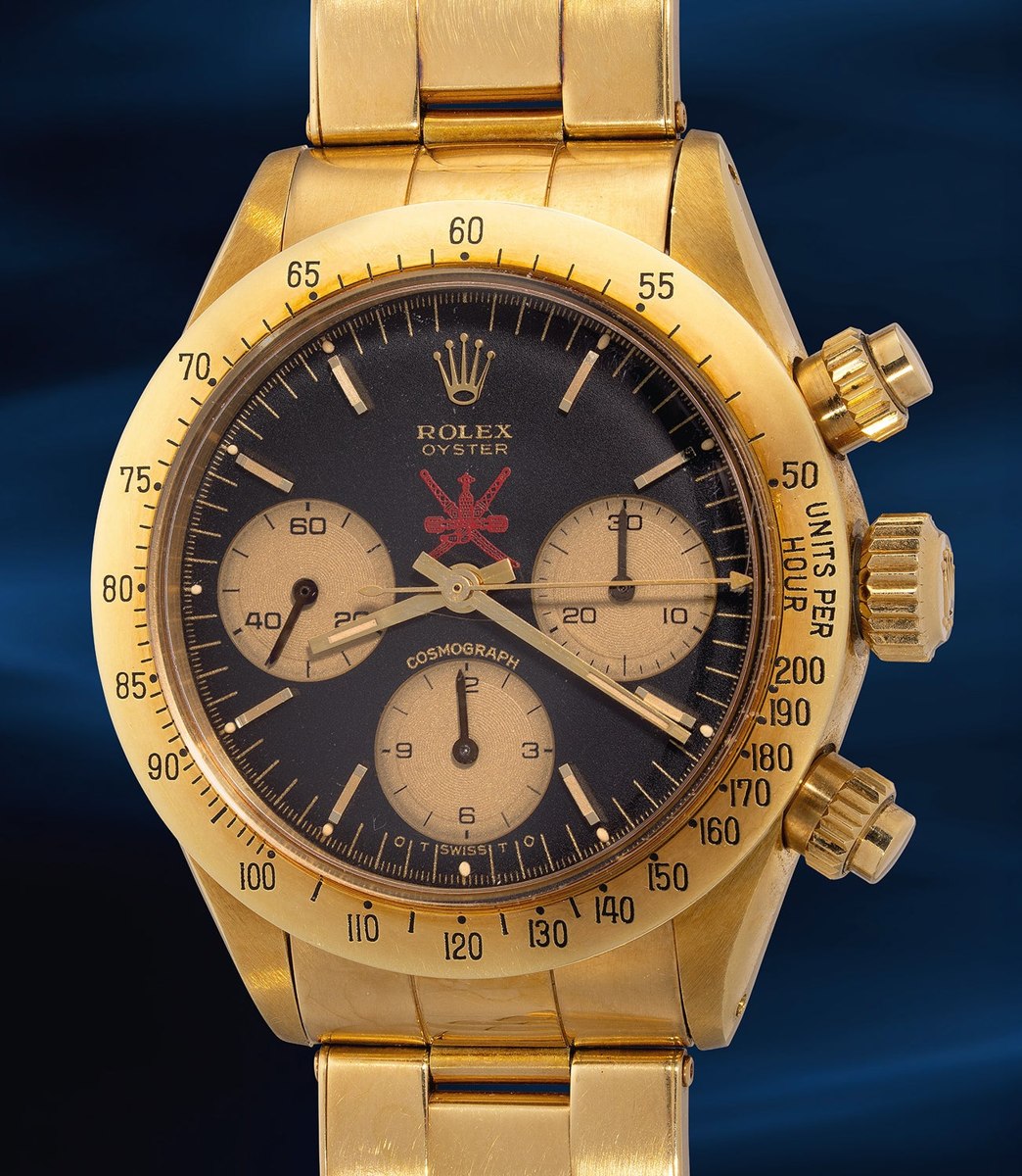 Rolex Oyster Cosmograph Ref. 6265 in 18K yellow gold with black dial featuring the red Khanjar emblem.