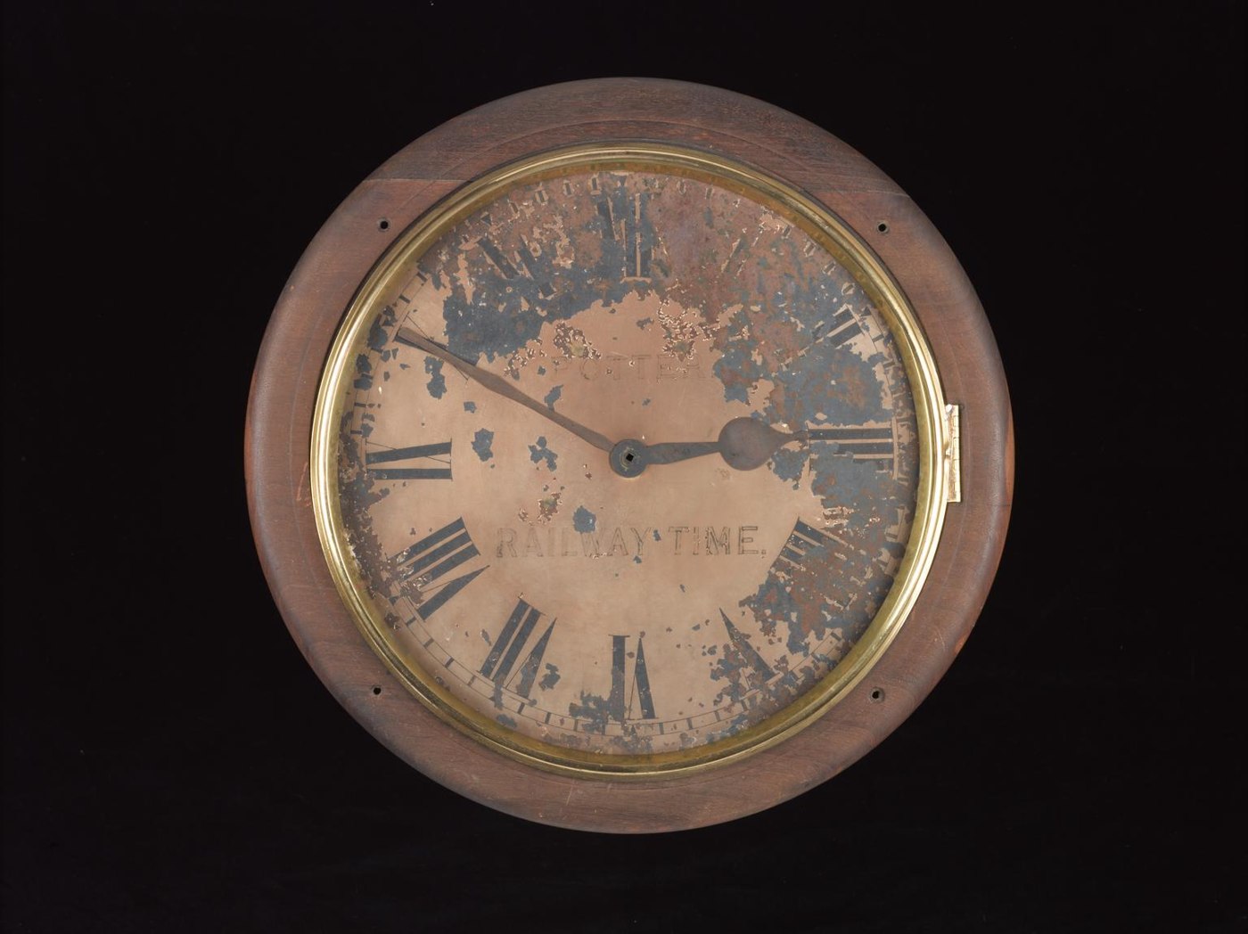 Front view of the clock dial with worn finish and the inscription 'POTTER' and 'RAILWAY TIME.'