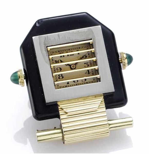 Front view showing black enamel brooch body, partially opened shutters, silvered dial, and malachite-set crowns