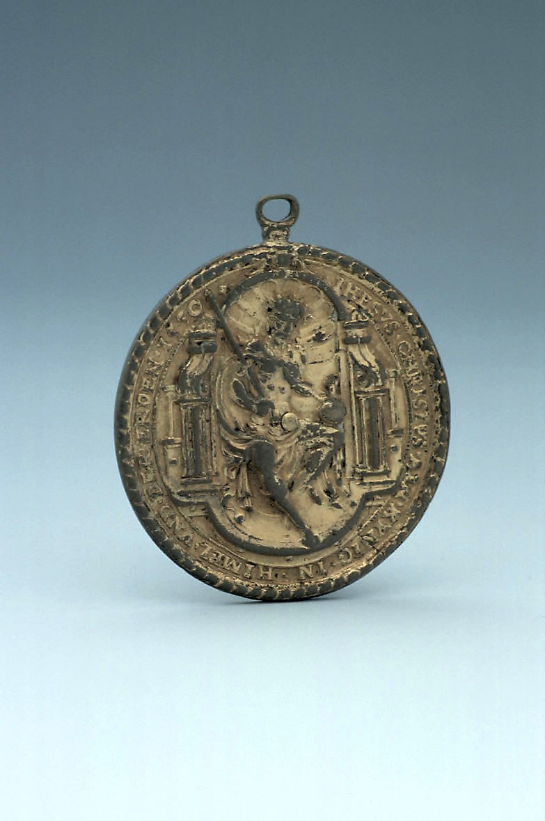 Obverse of the vertical disc dial showing the enthroned Christ figure in relief.