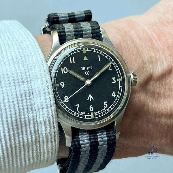 Front view of the Smiths W10 wristwatch on a wrist showing the dial, hands, and striped strap