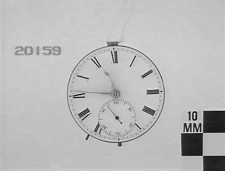 View of the white enamel dial and Roman numerals of the pocket watch movement.