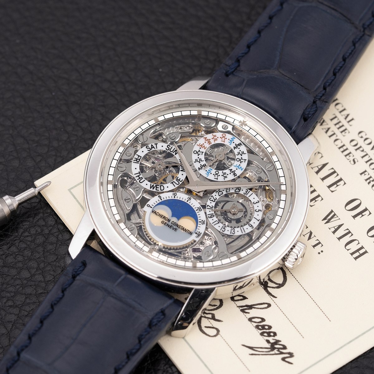 Dial and case view of the Vacheron Constantin Traditionnelle Perpetual Calendar Skeleton, ref. 43172/000P-9236, resting with certificate and stylus tool