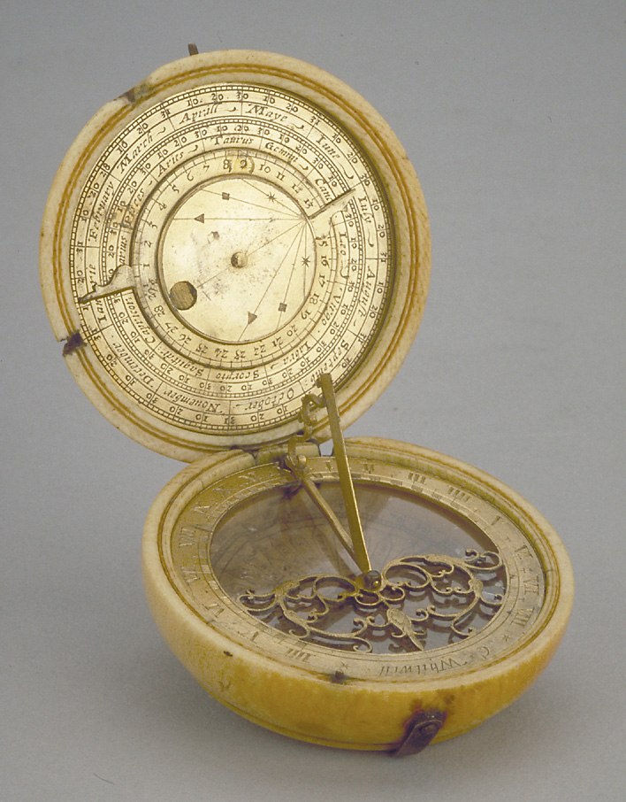 The ivory and gilt brass astronomical compendium open to show the dial, compass, and internal lunar volvelle.