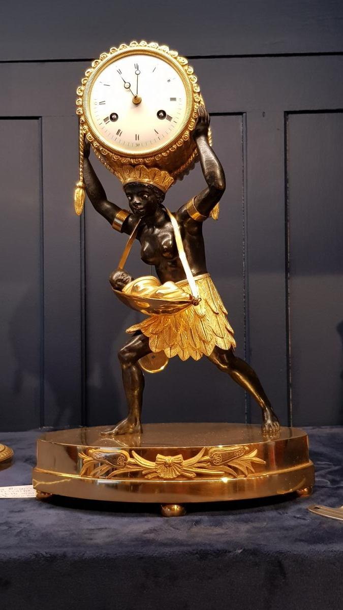 Front view of the Empire gilded and patinated bronze mantel clock depicting the nurse supporting the drum dial