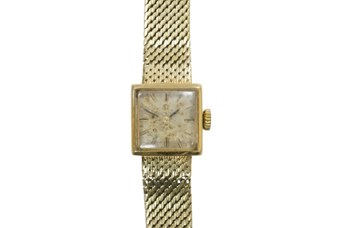 Front view of the lady's Omega 14k gold square wristwatch on integrated mesh bracelet