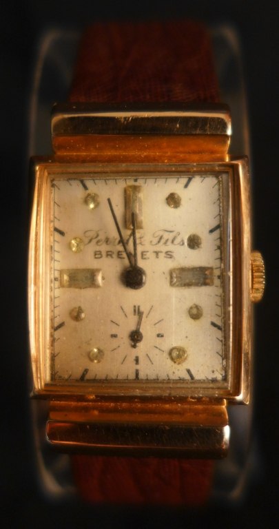 Front view of the Perret & Fils Brenets 14K rose gold square wristwatch on a brown lizard strap
