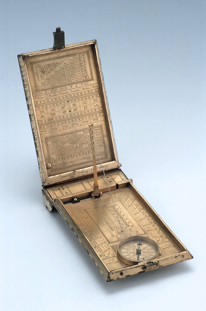 The astronomical compendium opened, showing the interior covers, the sundial, and the compass.