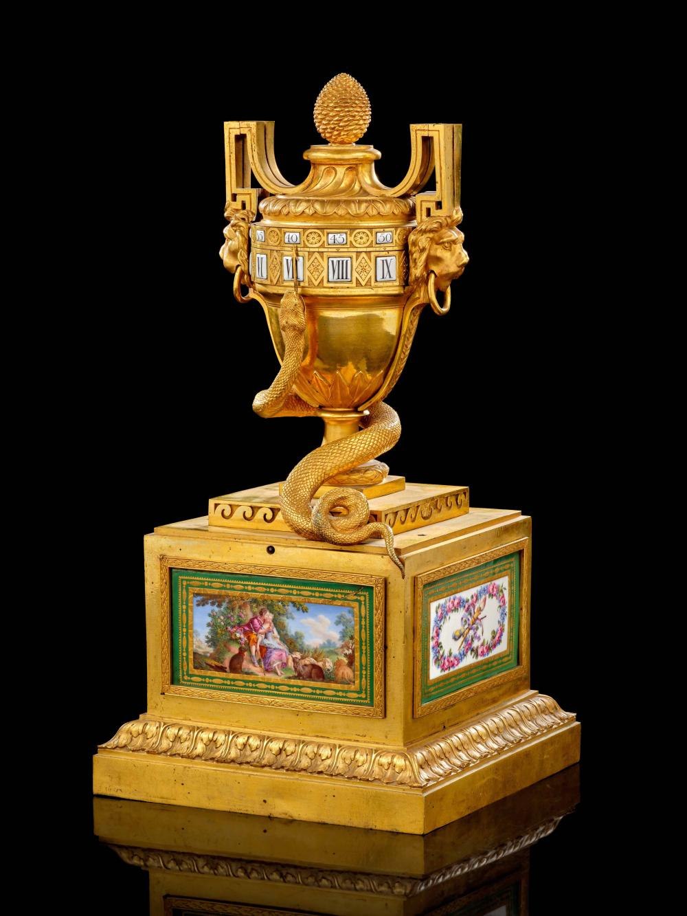 A view of the rotating dial clock showing the gilt-bronze vase, serpent pointer, and decorated Sèvres porcelain base.