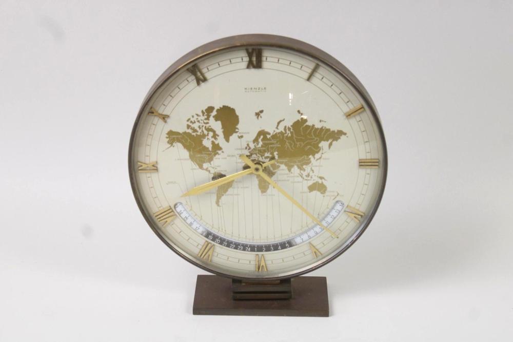 Front view of the Heinrich Moller for Kienzle world desk clock showing the world map dial, Roman numerals, and the 24-hour track.
