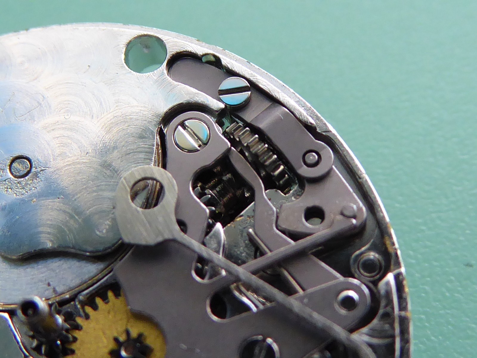 Rolex 2030 keyless-works close-up — yoke and sliding pinion in situ; source reports the yoke has slipped out of the pinion groove; workshop fault example