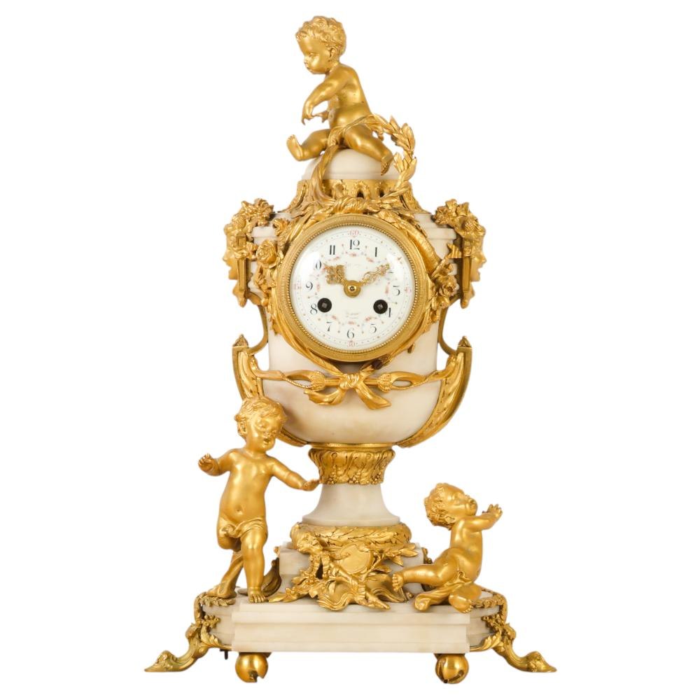 Front view of French Louis XVI style doré bronze and white marble mantel clock with putti mounts