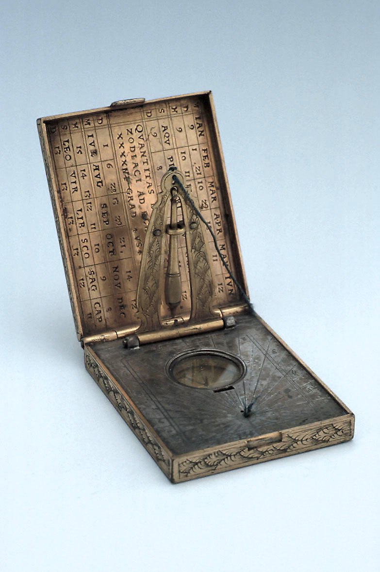 Horizontal dial in open position, revealing the internal string gnomon, compass, and zodiac/daylight table.