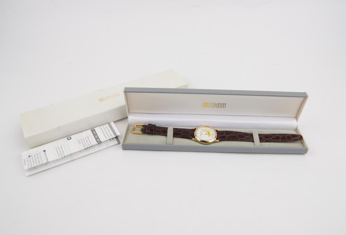 Ricoh quartz analogue wristwatch with presentation case and instructions, c.1996.