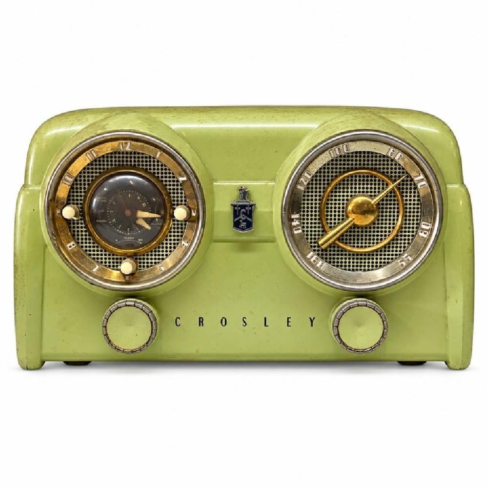 Front view of the Crosley tabletop clock radio showing dual dials, control knobs, and metallic trim.