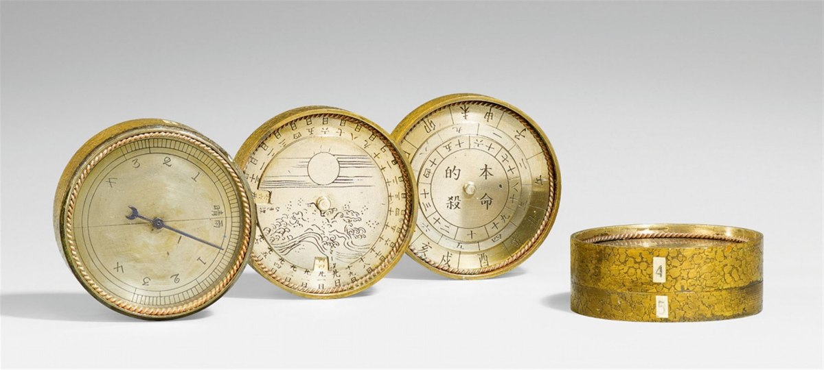 Disassembled tiers of the astronomical compendium showing dials and acid-etched case sections