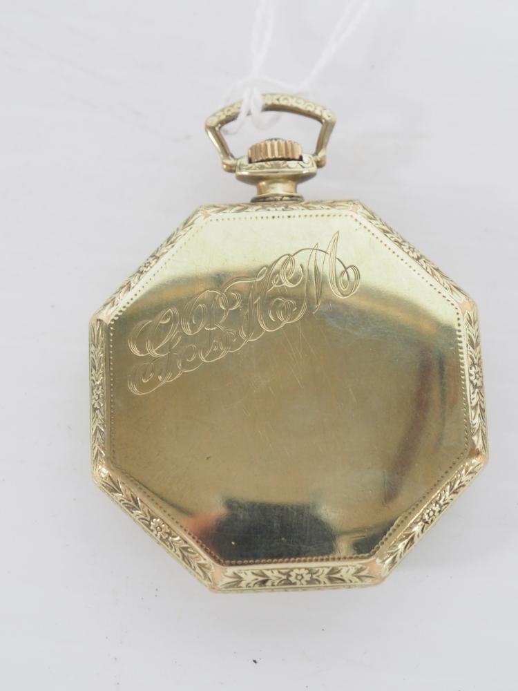 Rear view of the octagonal pocket watch case showing engraved script and decorative borders