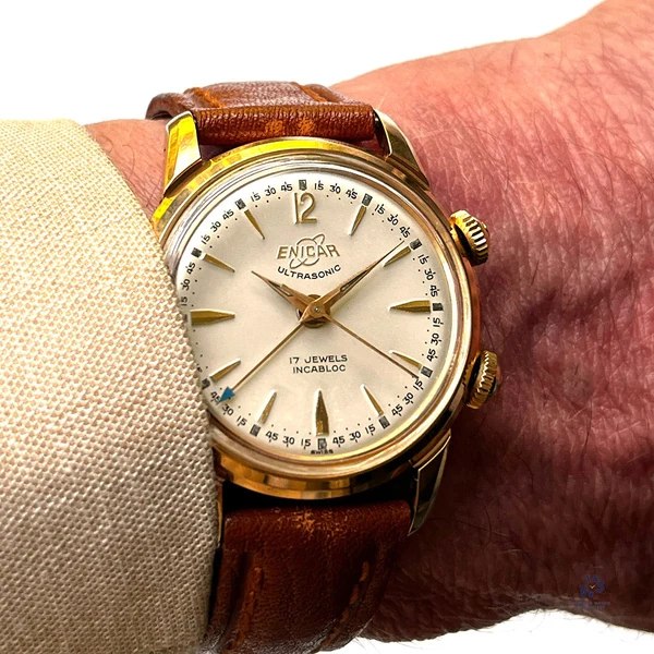 Front view of the Enicar Ultrasonic alarm watch on the wrist showing dial and dual crowns