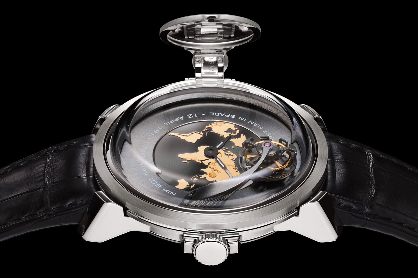 Close-up view of the BLU Gagarin watch, highlighting the rotating magnifying glass over the gold world-map dial and Vostok-themed tourbillon.