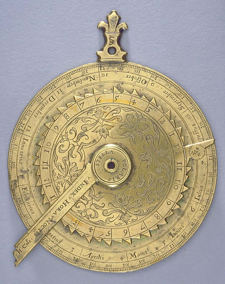 Front view of the gilt brass nocturnal by Humfrey Cole, featuring the calendrical scale, hour volvelle, and index arm.